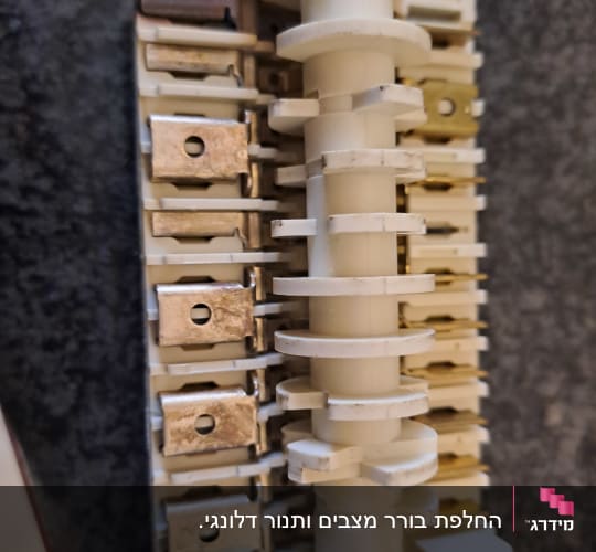 רכיב חשמלי עם חיבורים מתכתיים ולוח פלסטיק